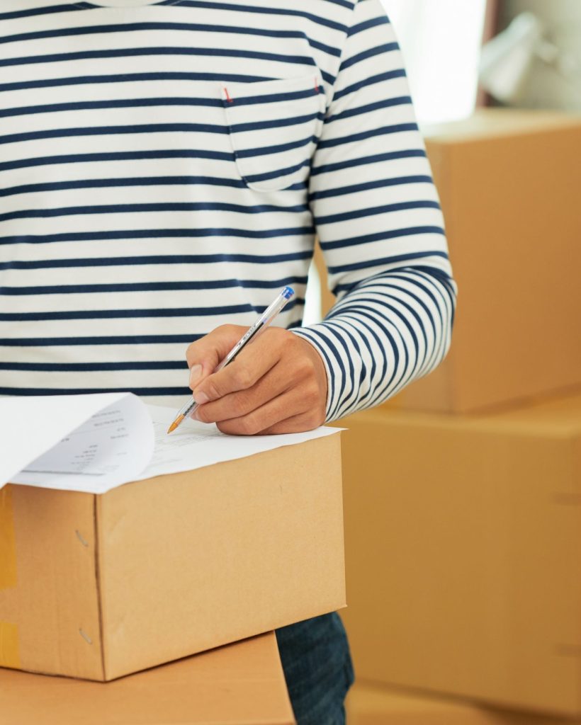 mid-section-man-striped-long-sleeve-shirt-filling-out-form-box (1)
